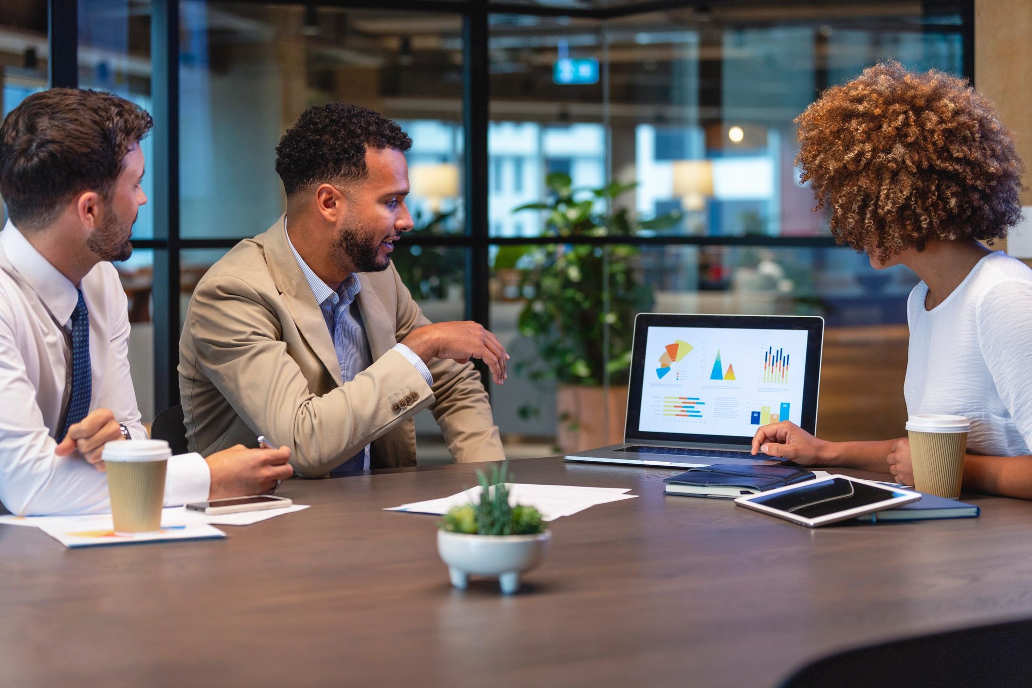 Three business people meeting and looking at a laptop
